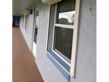 Exterior view of condo building with walkway, windows, and door at 333 Lake Howard Nw Dr # 312D, Winter Haven, FL 33880