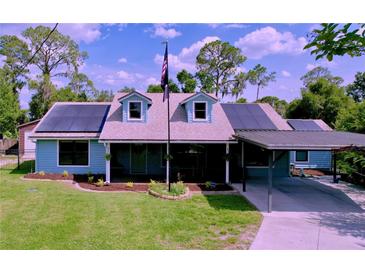 Charming single-Gathering home featuring a covered carport, solar panels, and a well-manicured lawn at 3705 Pine Cir, Lake Wales, FL 33898
