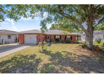 Charming brick home with a well-manicured front yard and mature shade trees, offering curb appeal at 40 Westridge Rd, Davenport, FL 33837