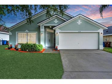 Charming single-story home with a well-maintained lawn, tidy landscaping, and two-car garage at 436 China Berry Cir, Davenport, FL 33837