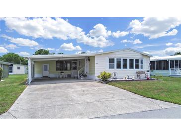 Charming single-story home featuring a covered carport and a neatly landscaped front yard with a decorative bench at 4941 Foxdale Dr, Lakeland, FL 33810
