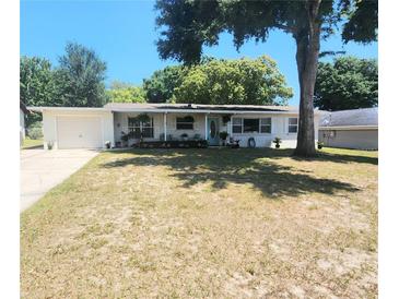 Charming single-story home with a well-kept lawn and a pop of color from the bright blue front door at 550 E Thelma St, Lake Alfred, FL 33850