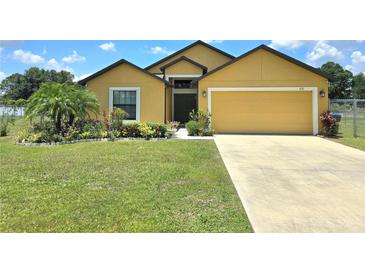 Inviting one-story home with a well-manicured lawn and colorful landscaping at 830 Cabaret Ct, Kissimmee, FL 34759