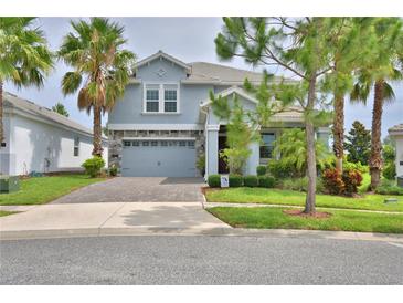 Charming two-story home boasts a paved driveway, a two-car garage, and well-maintained landscaping at 1433 Bunker Dr, Davenport, FL 33896