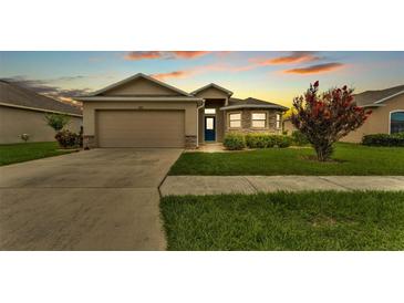 Charming single-story home with a well-manicured lawn, stone accents, and a two-car garage at 1765 Kingsmill Dr, Bartow, FL 33830