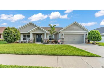 Charming single-story home with a well-manicured lawn, cozy front porch, and attached two-car garage at 204 Walkers Point Dr, Auburndale, FL 33823