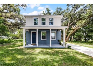 Charming two-story home featuring a blue exterior, white trim, covered porch, and a well-maintained lawn at 2052 W Elliott St, Lakeland, FL 33805