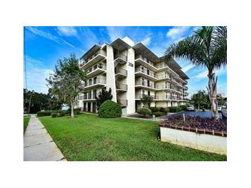 Multi-story condo building with green lawn and meticulous landscaping offers a welcoming curb appeal at 208 Lake Howard Nw Dr # 104, Winter Haven, FL 33880