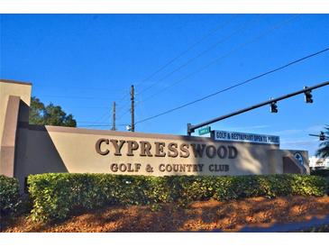 Cypresswood Golf & Country Club sign with manicured shrubs sits beneath a blue sky. Golf & Restaurant Open to Public sign is visible at 2835 Wingfoot Ct, Winter Haven, FL 33884