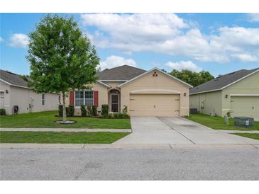 Charming single-story home featuring a manicured lawn, mature tree, and a two-car garage at 536 Squires Grove Dr, Winter Haven, FL 33880