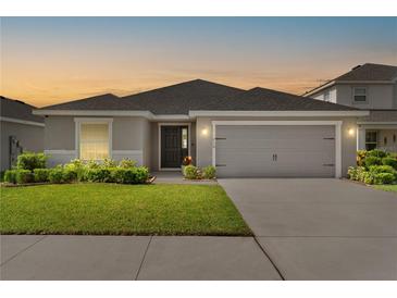 Charming single-story home featuring a well-manicured lawn, a two-car garage, and a welcoming front entrance at 716 Vittorio Dr, Winter Haven, FL 33884