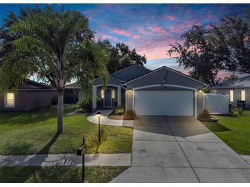 Charming single-story home with a well-maintained lawn and inviting curb appeal under a colorful sunset sky at 124 Eagle Point Blvd, Auburndale, FL 33823