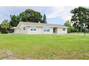 Charming single-story home featuring a well-maintained lawn and neutral-colored exterior at 1476 Avenue F Ne, Winter Haven, FL 33881