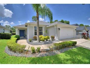 Charming single-story home with landscaped front yard, palm tree, and blue front door at 2350 Paulette Dr, Haines City, FL 33844