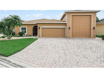 Well-maintained home with a two-car garage, mature landscaping, and a welcoming entryway offers great curb appeal at 3802 Litchfield Loop, Lake Wales, FL 33859