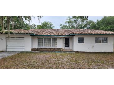 Charming single-story home featuring a red tile roof, front lawn, and attached one car garage at 4160 Poinciana Dr, Indian Lake Estates, FL 33855