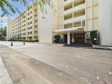 Exterior view of the building featuring the covered front entrance and landscaping at 700 Mirror Nw Ter # 702, Winter Haven, FL 33881