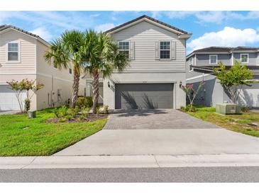 Charming two-story home with a brick paved driveway and well-maintained landscaping at 7247 Oakmoss Loop, Davenport, FL 33837