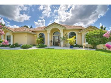 Charming single-story home with a well-manicured lawn and beautiful landscaping at 10708 Belo Horizonte Ave, Clermont, FL 34711