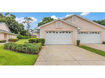 Charming home featuring a white garage door, complemented by lush landscaping and a well-maintained driveway at 13 Enclave Dr, Winter Haven, FL 33884