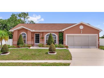 Charming single-story home featuring a well-manicured lawn and a two-car garage at 1366 Merrimack Pl, Davenport, FL 33837