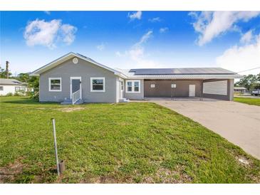 Charming single-story home with gray siding, metal roof, solar panels and spacious carport at 2218 Melbourne Ave, Haines City, FL 33844
