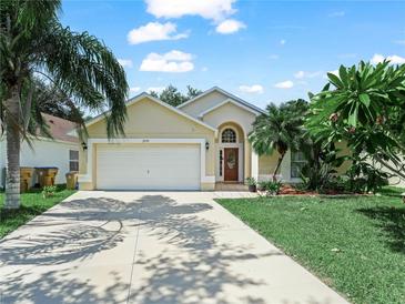 Charming single-story home with a well-maintained lawn, palm trees, and a two-car garage at 2538 Crown Ridge Cir, Kissimmee, FL 34744