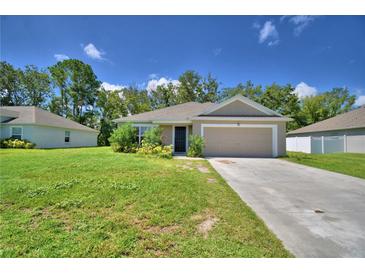 Charming single-story home featuring a well-maintained lawn, inviting entrance, and attached two-car garage at 286 Cove At Eagle Lake Cir, Eagle Lake, FL 33839