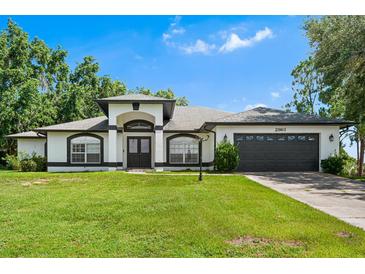 Charming single-story home with manicured lawn, dark trim and a two car garage at 2861 Pond View Dr, Haines City, FL 33844