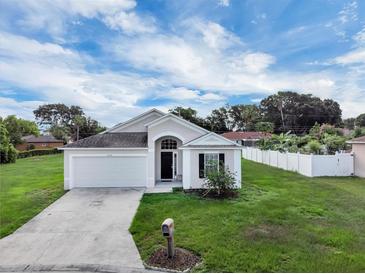 Charming single-story home features a well-manicured lawn and a two-car garage at 5424 Moon Valley Dr, Lakeland, FL 33812