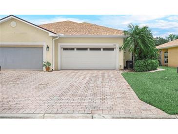 Well-maintained home with a brick paver driveway that leads to a two car garage with beautiful landscaping at 1349 Innsbruck Ct, Winter Haven, FL 33884