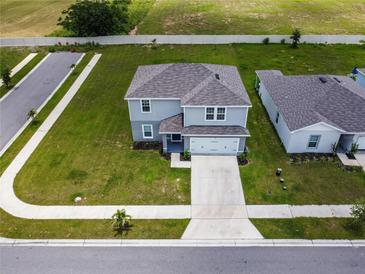 Aerial view of a two-story home featuring a well-manicured lawn and gray color scheme at 137 Piave St, Haines City, FL 33844