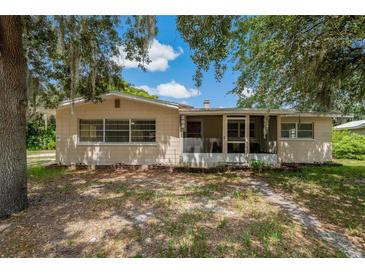 Charming single-story home with mature trees, a screened-in porch, and a tidy, shaded front yard at 208 Lake Dale Dr, Auburndale, FL 33823