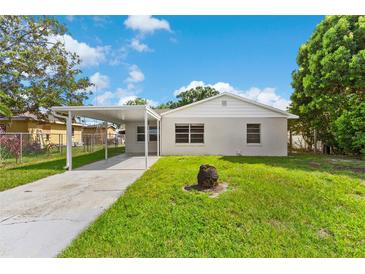 Charming single-story home featuring a carport and well-maintained lawn at 216 Pike St, Auburndale, FL 33823