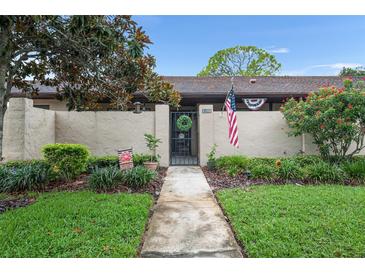 Charming home featuring a landscaped front yard with walkway, flowerbeds, and an American flag at 2282 Firestone Pl, Winter Haven, FL 33884