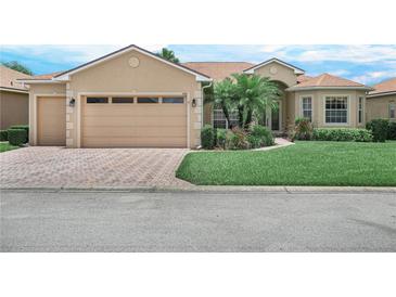Charming single-story home with a two-car garage, well-manicured lawn, and mature palm trees at 5200 Pebble Beach Blvd, Winter Haven, FL 33884