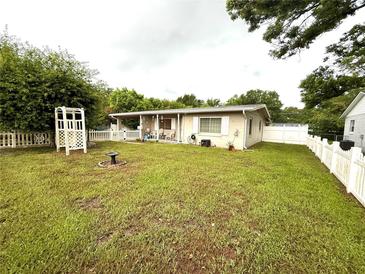 Spacious backyard with a charming white picket fence and well-maintained lawn at 7814 Plunkett Ave, Orlando, FL 32810