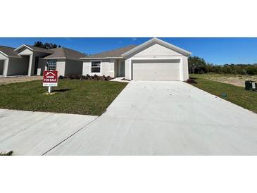 Charming single-story home featuring a two-car garage, well-maintained lawn, and inviting curb appeal at 221 Harper Estates Cir, Lake Wales, FL 33859