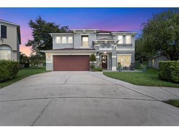 Two-story house with a gray exterior, red door, and landscaped yard at 1541 Truscott Ct, Mount Dora, FL 32757