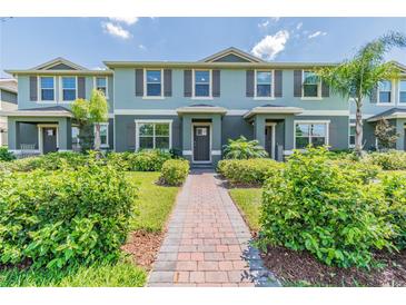 Two-story townhome with gray exterior, landscaped yard, and brick walkway at 16039 Juniper Inlet Aly, Winter Garden, FL 34787