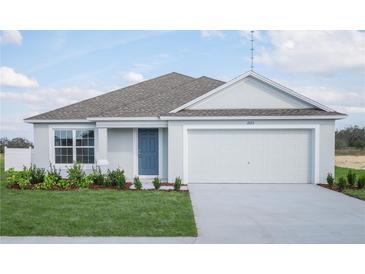 Charming single-story home featuring a two-car garage, manicured lawn, and a welcoming blue front door at 2125 Emma Ln, Lake Wales, FL 33859