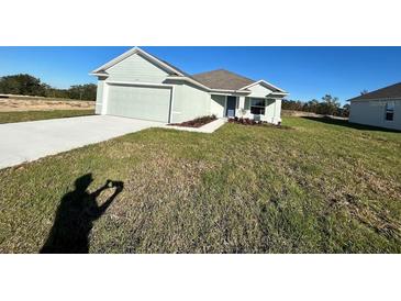 Newly constructed home with a two-car garage and well-manicured lawn at 2177 Emma Ln, Lake Wales, FL 33859