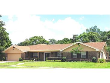 Brick ranch home with attached garage, landscaping, and large yard at 413 Sandy Hill Dr, Longwood, FL 32779