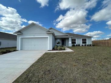 Charming single-story home with a two-car garage and a well-maintained lawn at 416 Central Ave, Frostproof, FL 33843