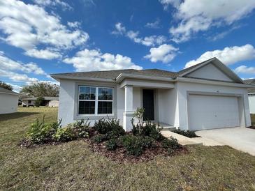 Charming single-story home with a well-manicured lawn and an attached one-car garage at 418 Central Ave, Frostproof, FL 33843