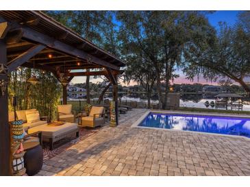 Relaxing patio with pergola, seating area, and pool overlooking lake at 1860 Lake Markham Rd, Sanford, FL 32771