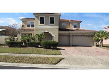 Two-story house with a three-car garage and manicured landscaping at 2802 Quiet Water Trl, Kissimmee, FL 34744