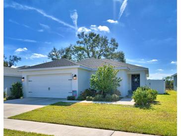 White house with a two-car garage and landscaped lawn at 4481 Reding Way, Lakeland, FL 33813