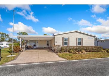 Single-wide manufactured home with covered patio and landscaped yard at 108 Dogwood Trl, Leesburg, FL 34748