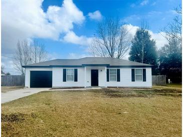 Newly constructed home with white siding, black accents, and a landscaped yard at 203 Juniper Way, Ocala, FL 34480
